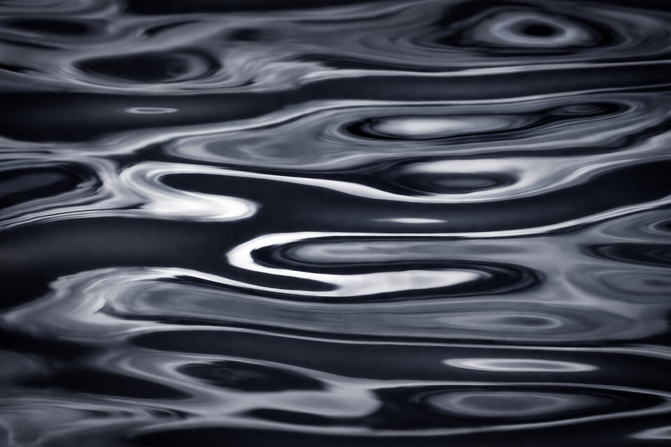 Reflections on the surface of the lake in New York's Adirondack Mountains rendered as abstract swirls of light.