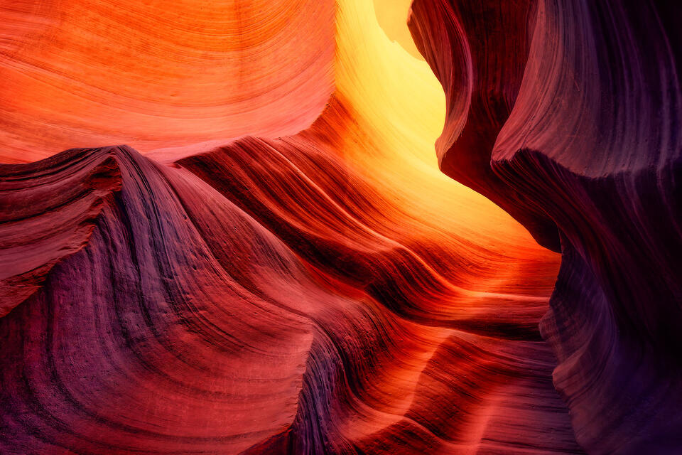 Warm light reflects and glows in the depths of Antelope Canyon, revealing shades of orange, red and purple.