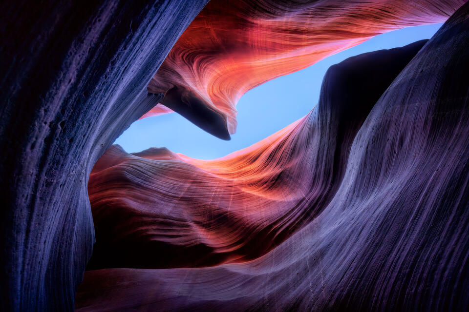 A sliver of blue sky is cradled by the swirling sandstone of Antelope Canyon.