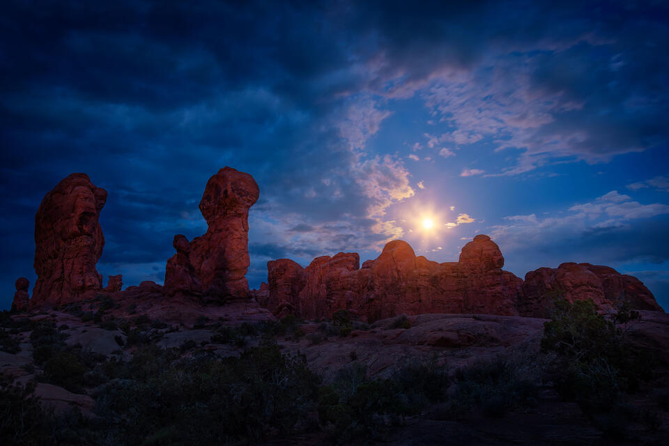 Moonlight faintly illuminates the rocky pinnacles of the Garden of Eden in Utah's Arches National Park.