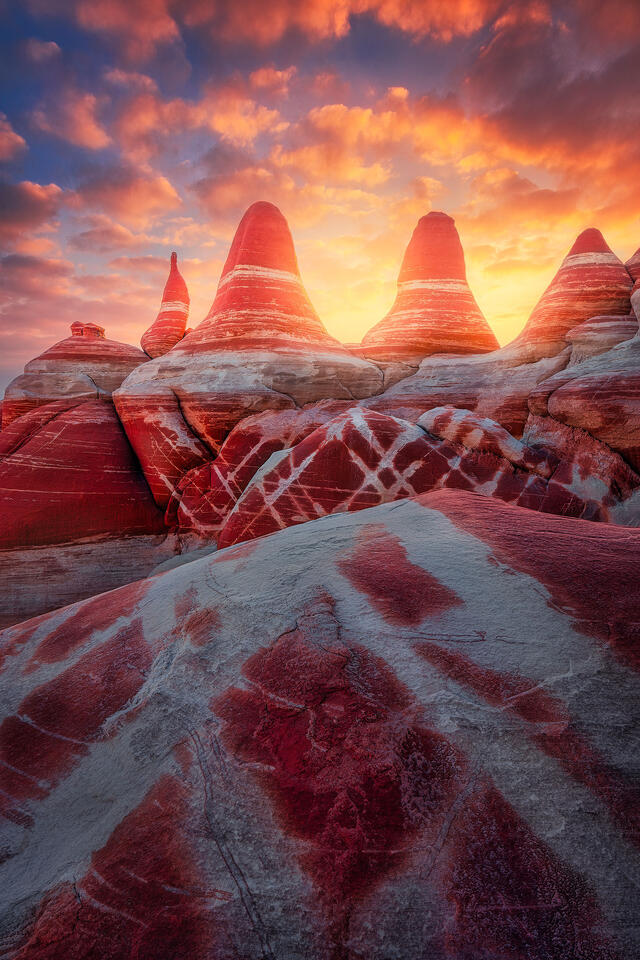 Sunset lights up the sky above a group of otherworldly rock formations that resemble ancient arrowheads.