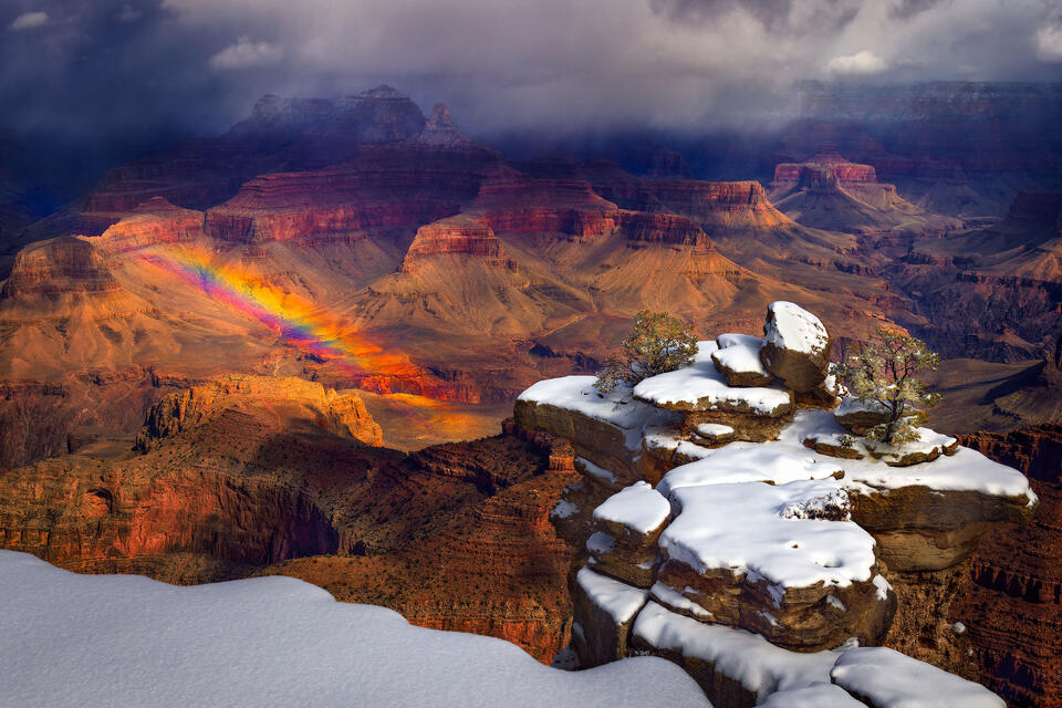 The Grand Canyon has an unusual combination of snow and a rainbow during the winter.