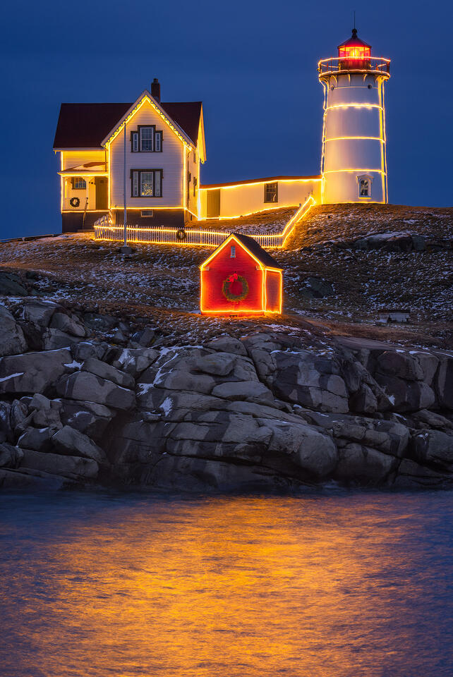 The Nubble Lighthouse is lit up at night during the Christmas season.