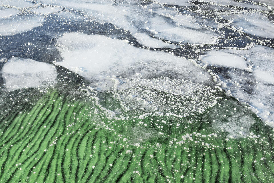The surface of Lake George flash froze overnight, giving a glimpse of summer sands below its icy surface.