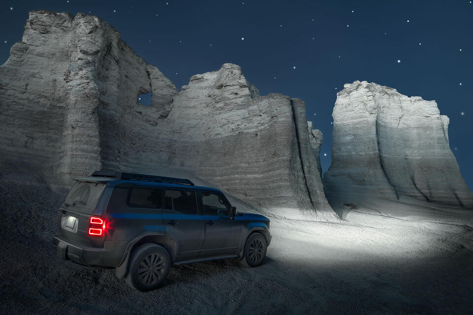 The headlights of a Land Cruiser illuminate the bizarre and beautiful chalk formations of Monument Rocks.