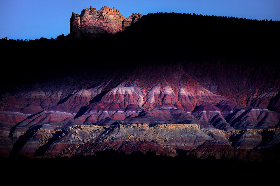 Morning light dramatically spotlights the colorful bentonite badlands of Southern Utah.