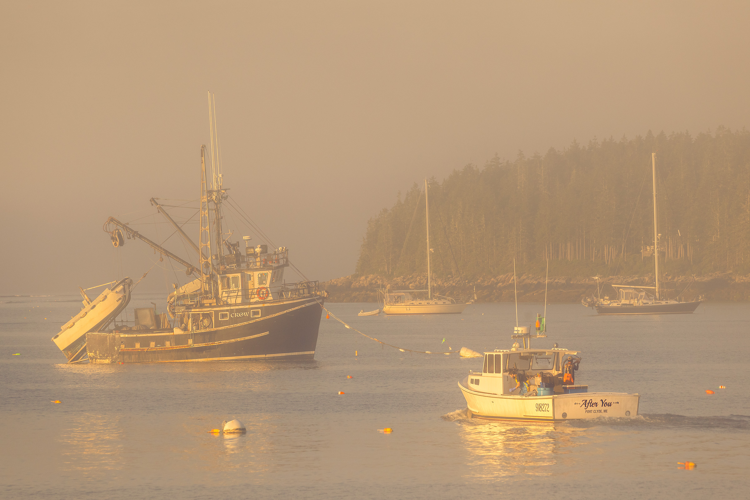 After You A lobster boat navigates through the foggy harbor of Port Cylde, Maine on a summer morning.